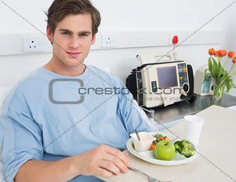 Handsome man having meal in hospital