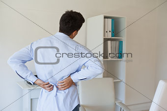 Casual businessman touching his sore back