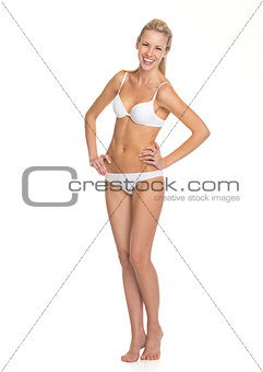 Full length portrait of smiling young woman in lingerie