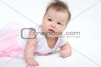 Newborn baby in pink dress smiling