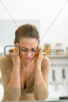 Portrait of stressed young woman in kitchen