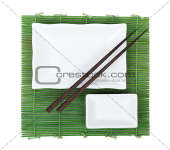 Chopsticks and utensils over bamboo mat