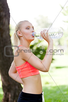 attractive young blonde woman drinking water outdoor sport