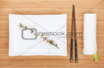 Empty plate, chopsticks and sakura branch