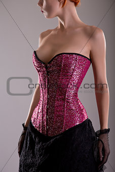 Close-up shot of elegant young woman in pink corset 