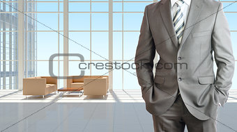 Businessman and large window in office building