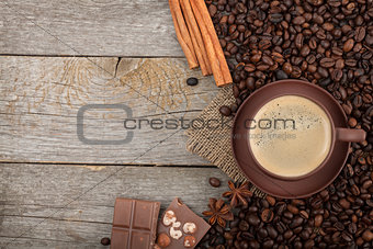 Coffee cup with spices and chocolate on wooden table texture