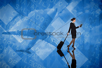 Composite image of businesswoman pulling her suitcase holding tablet