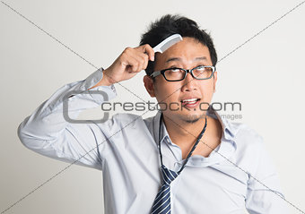 Asian businessman combing hair 