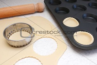 Lining a bun tin with circles of rolled out pastry