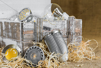 GU10 LED bulbs on straw in front of old delivery wooden box with