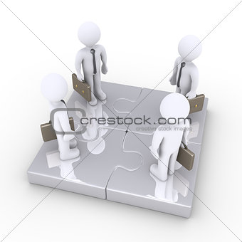 Four businessmen stand together on puzzle pieces