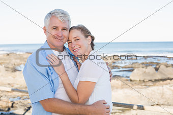 Happy casual couple embracing by the sea
