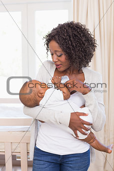 Happy mother feeding her baby boy his bottle