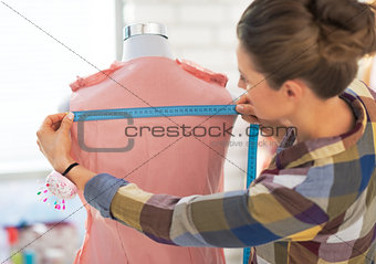 Tailor woman working with dress in studio