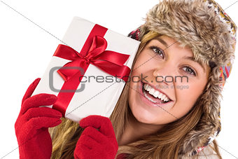 Happy blonde in winter clothes holding gift