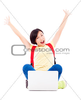 excited young student girl sitting with a laptop and raising arm