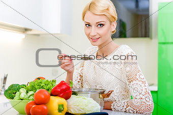 Young woman tasting soup