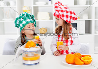 Little chef girls tasting the orange juice they made