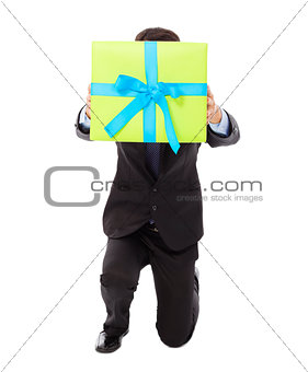 Businessman holding a gift box and kneel down .