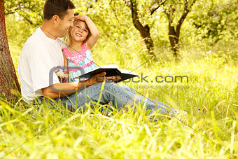 young father with his little daughter reading a book