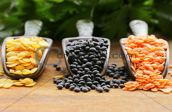 red, yellow and black lentils on a wooden background