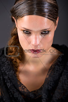 Beautiful brunette in tears isolated on black