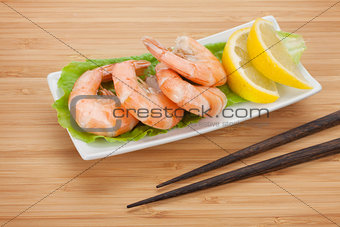 Cooked shrimps with lemon and chopsticks