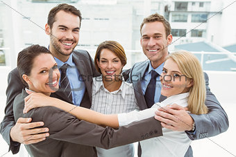 Business people with arms around in office
