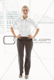 Beautiful businesswoman with hands on hips in office