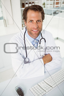 Smiling male doctor sitting at medical office