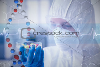 Composite image of scientist in protective suit analyzing pills