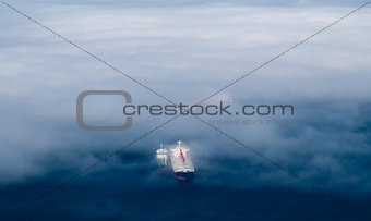 Cargo ships emerging from fog