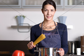 Young housewife preparing a healthy Italian pasta