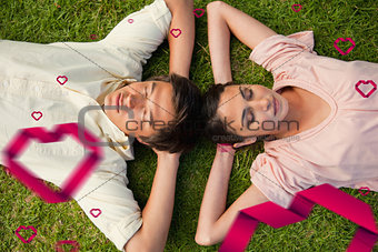 Composite image of two friends lying head to head with both hands behind their neck