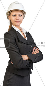 Businesswoman wearing hard hat, her arms crossed on breast