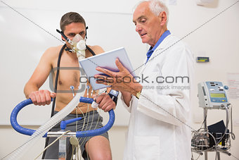 Doctor showing tablet pc to man doing fitness test