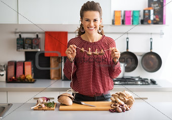 Young housewife drying mushrooms