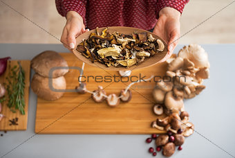 Closeup on young housewife showing mushrooms