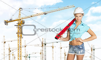 Woman in hard hat with large builders level on her shoulder