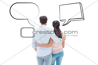 Composite image of attractive young couple standing with arms around
