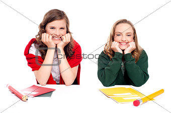 Happy young girls sitting idle with notebooks