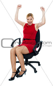Excited woman sitting in chair. Isolated