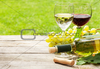 White and red wine glasses, wine bottle and white grape