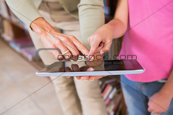 Teacher and pupil touching tablet screen