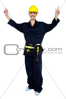 Smiling lady worker in jumpsuit raising her hands