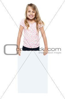 Pretty young girl showcasing blank whiteboard