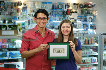 Portrait Of Happy Shop Owners Showing First Dollar Earning