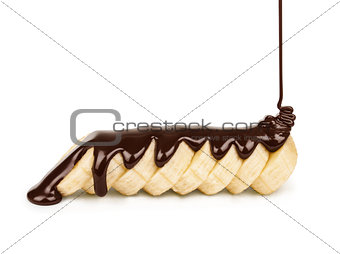 dark chocolate is poured on the banana slices on a white backgro