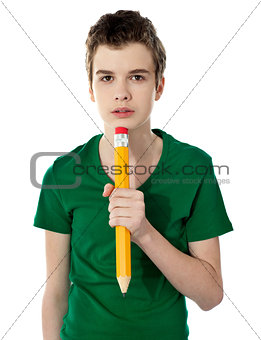 School boy thinking while holding pencil